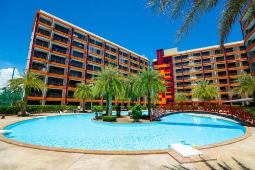 Un complejo con una gran piscina frente a un edificio. en The Signature Suite, en Ban Mai Salae