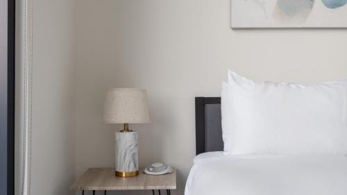 a bedroom with a bed and a table with a lamp at Kasa at The Waller Austin in Austin