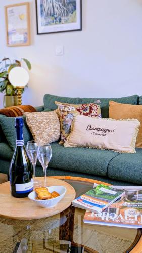 a living room with a couch and a table with wine glasses at LE CEMAROSE Cottage & Spa Terrace Garden & lovely View in Épernay