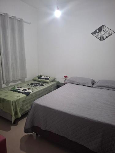 a bedroom with two beds and a window at Casa com piscina! Descanso e Lazer in Itapoa