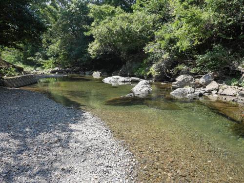 a river with rocks and trees on the side at 横輪弘法の宿 in Ise