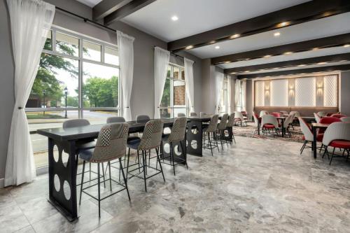 a dining room with tables and chairs and windows at Courtyard by Marriott Athens Downtown in Athens