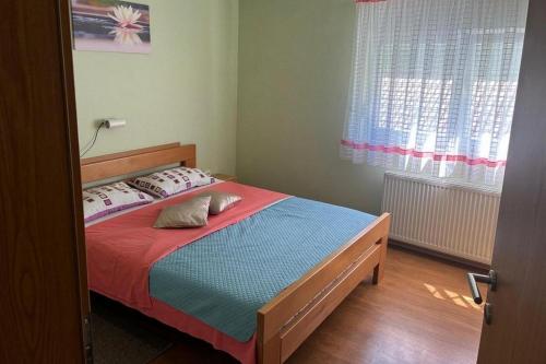 a bedroom with a bed with a red and blue blanket at Apartments with parking space Tuheljske Toplice, Zagorje - 24875 in Tuheljske Toplice
