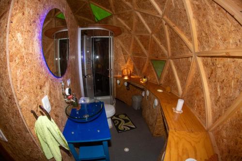a bathroom with a toilet and a mirror in a room at Hotel Ecologico Makalombia in La Macarena