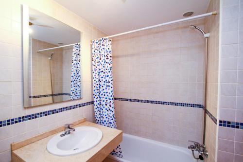 een badkamer met een wastafel, een bad en een spiegel bij Roura 2 Planetcostadorada in La Pineda
