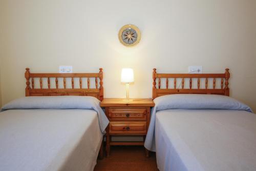 Un dormitorio con dos camas y un reloj en la pared. en Sinia apartment, en Cambrils