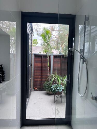 a bathroom with a shower and a glass door at Nelson - architect designed oasis Port Melbourne in Melbourne