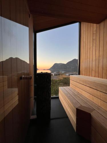 a room with a window with a view of the ocean at Hoda Cabin - Luxury lodge with jacuzzi and sauna in Lyngværet