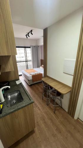 a bathroom with a sink and a bedroom with a bed at Studio 604 - Seu refúgio Urbano no Coração de São Paulo - Wifi, Vaga, Academia, Lavanderia, Mercado e Rooftop in Sao Paulo