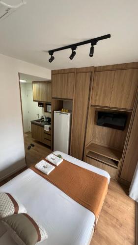 a kitchen with a large white bed in a room at Studio 604 - Seu refúgio Urbano no Coração de São Paulo - Wifi, Vaga, Academia, Lavanderia, Mercado e Rooftop in Sao Paulo
