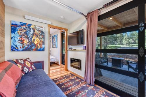 a living room with a couch and a large window at Two Pines - Unique container home w/hot tub - Downtown - Trailer Parking - Pet friendly in McCall
