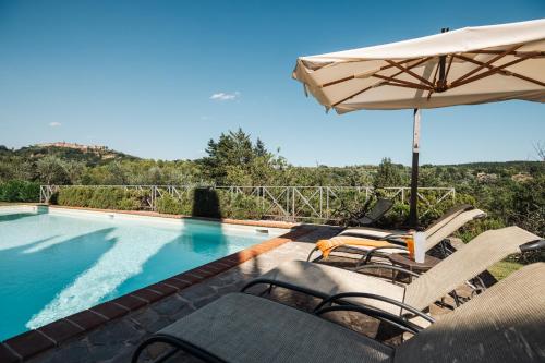 a swimming pool with chairs and an umbrella next to it at Charming Farmhouse in Monteleone D'Orvieto in Monteleone dʼOrvieto