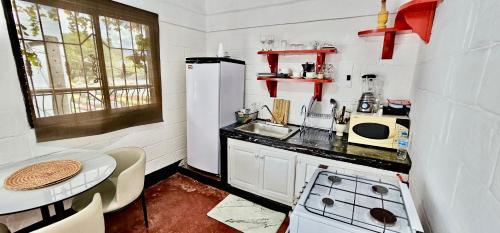 a small kitchen with a sink and a stove at Brisas de Jarabacoa in Jarabacoa