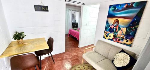 a living room with a couch and a table and a painting at Brisas de Jarabacoa in Jarabacoa