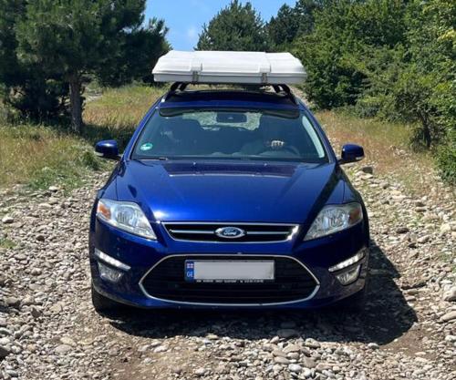 a blue car parked on a gravel road at Nomad Campers by Wolf Camp Georgia in Tbilisi City