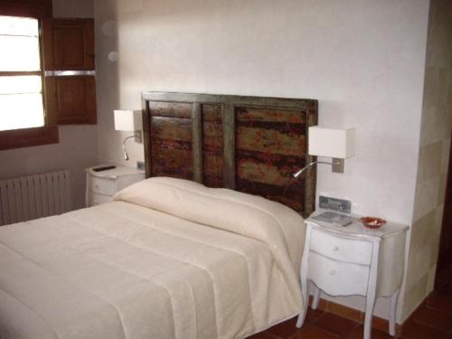 a bedroom with a white bed and two night stands at Hotel Villa de Alquézar in Alquézar