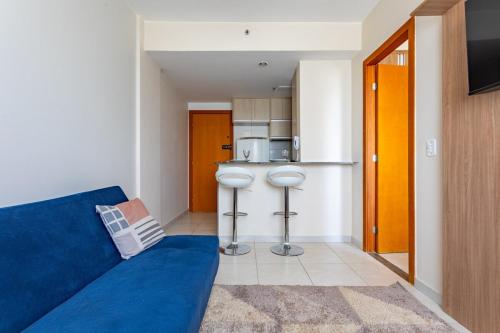 a living room with a blue couch and a kitchen at Luxury apartment next to Águas Claras Shopping Mall in Brasilia