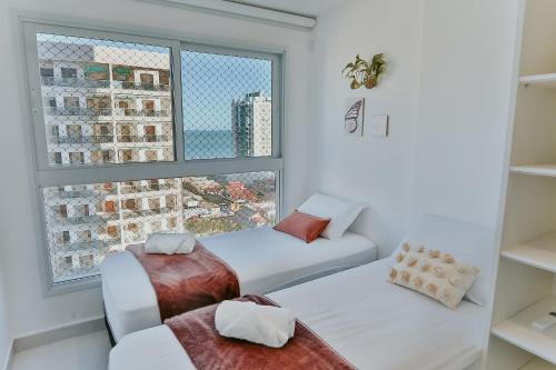 イタパリカにある2Q moderno c/ Piscina e Academiaのベッドが2つと窓のある部屋