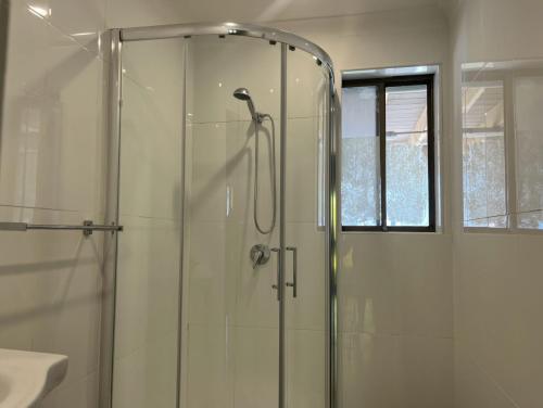 a shower with a glass door in a bathroom at Magnolia in Culburra Beach