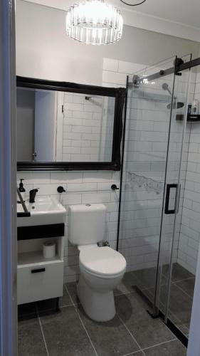 a bathroom with a toilet and a sink and a shower at Sojourn - Culburra Beach in Culburra Beach