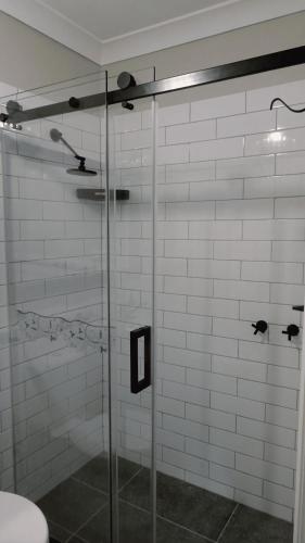 a bathroom with a shower with a glass door at Sojourn - Culburra Beach in Culburra Beach