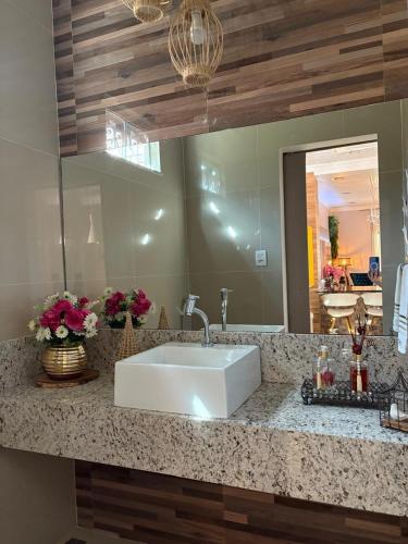 a bathroom counter with a sink and a mirror at Aconchego de luxo para COP 30 in Castanhal
