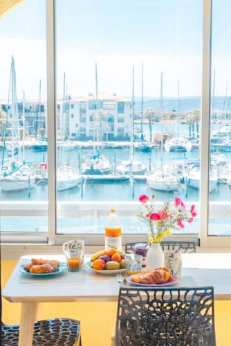 a table with food on it with a view of a marina at Les Terrasses du Port - VUE Port - Wifi - Parking - Clim in Leucate-Plage