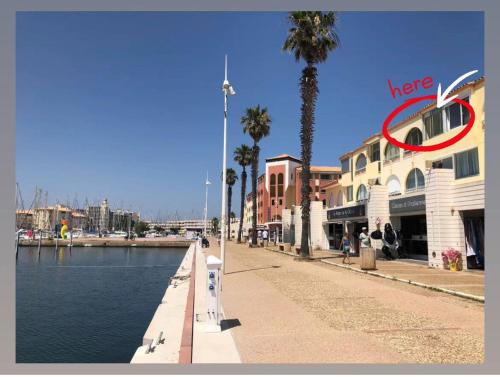 a building with a red circle on it next to a canal at Les Terrasses du Port - VUE Port - Wifi - Parking - Clim in Leucate-Plage