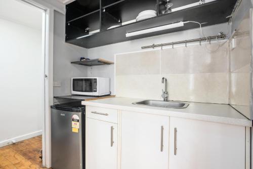 a kitchen with a sink and a microwave at Carlton loft studios. Tiny house movement. in Melbourne