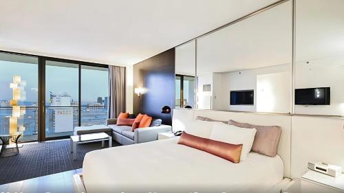 a bedroom with a white bed and a living room at StripSuite Palms Place BALCONY Hotel,Resort & Casino in Las Vegas