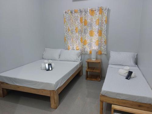 a bedroom with two beds and a window at BC Lodge in Puerto Princesa City