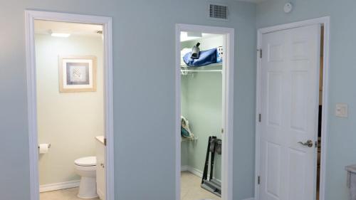 a bathroom with a toilet and a white door at Surfside II #109 home in Coffeyville