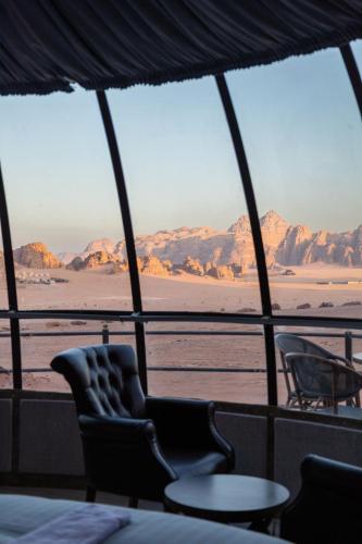 a view of the desert from a room with chairs and a table at Mars Land Luxury Camp in Wadi Rum