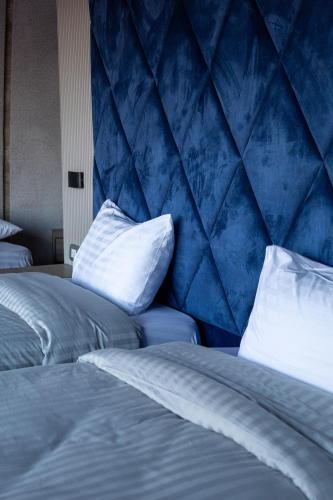 a bedroom with two beds and a blue wall at Mars Land Luxury Camp in Wadi Rum