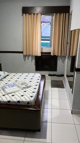 a bed sitting in a room with a window at Hotel estrela da lapa in Sao Paulo