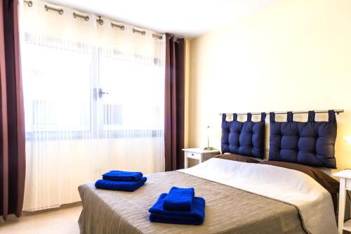 two blue towels on a bed in a bedroom at Pueblito in Corralejo
