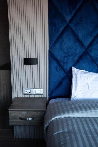 a bedroom with a bed with a blue headboard and a night stand at Mars Land Luxury Camp in Wadi Rum