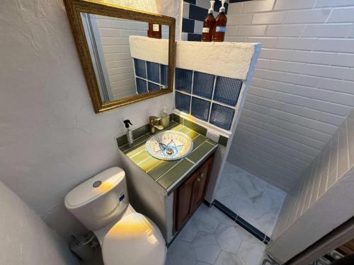 a bathroom with a toilet and a sink and a mirror at Casa Luna Jericó in Jericó