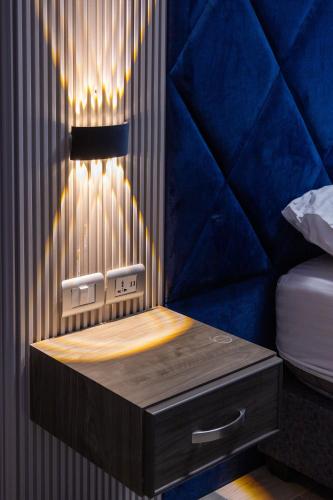 a bed room with a night stand next to a bed at Mars Land Luxury Camp in Wadi Rum