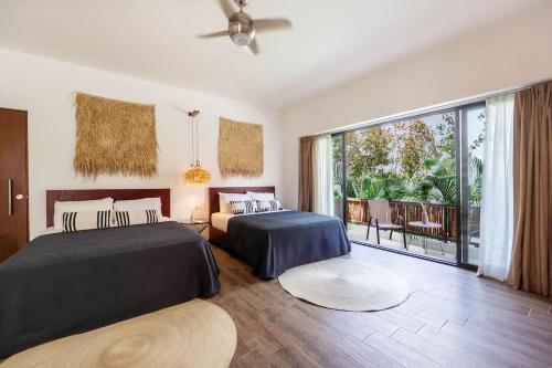 a bedroom with two beds and a balcony at 18-Bed 9BD Hotel Villa - Pool & Kitchen - Full Concierge in Tulum