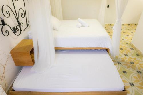 a couple of beds in a room at Hotel Bahia Del Faro in Guatapé