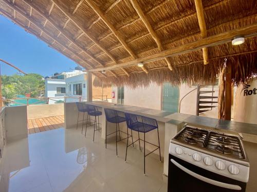 a kitchen with a stove and a bar with stools at Casa Cielo Cancun in Cancún