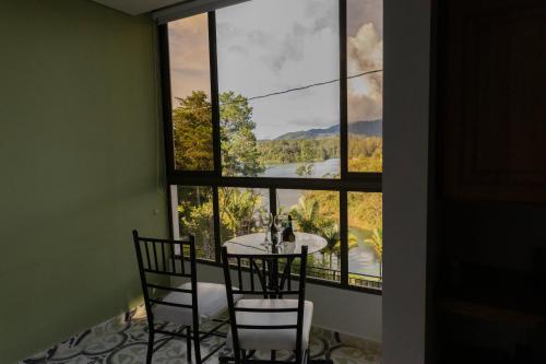 a room with a table and chairs and a large window at Hotel Bahia Del Faro in Guatapé