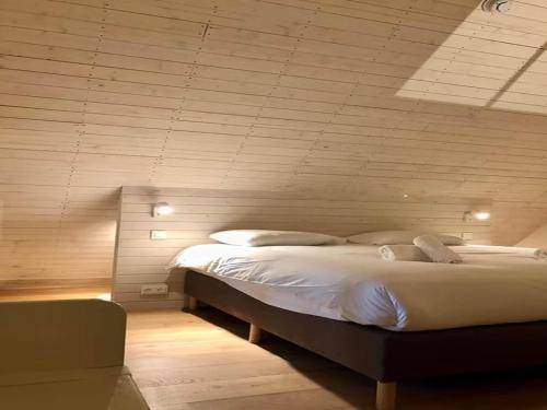 a bedroom with a large bed in a room at 2-bedroom cottage with park and deer park in Haltinne