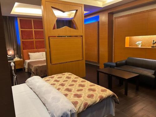 a room with a bed and a couch and a table at 里昂晶鑽汽車旅館 in Chung-ch'üan-li