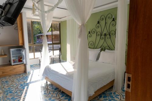 a bedroom with a bed with curtains and a balcony at Hotel Bahia Del Faro in Guatapé