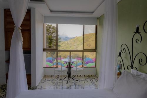 a bedroom with a bed and a table and a window at Hotel Bahia Del Faro in Guatapé