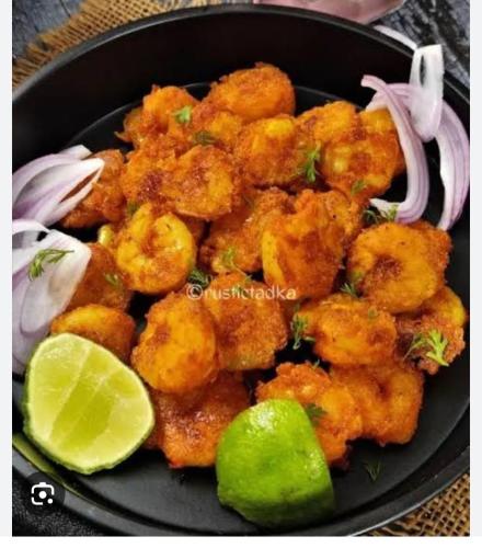 a plate of food with tater tots and a lime at Mangala Residency in Cola