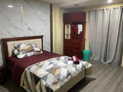 a bedroom with a bed and a dresser and a mirror at HABITACIÓN DELUXE Central in Machala