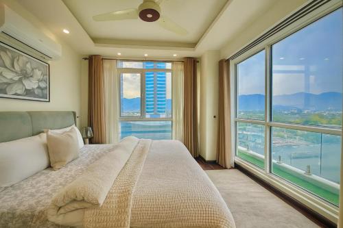 a bedroom with a bed and a large window at Elysium Grand Luxury Apartments Fronting Centaurus Mall Islamabad in Islamabad